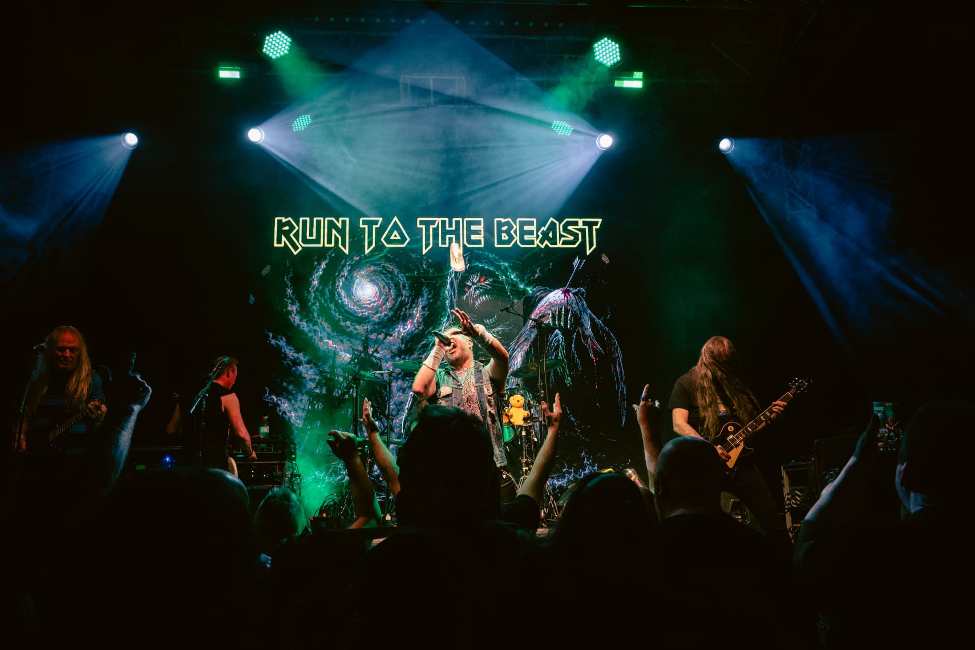 Run to the Beast performing at The Button Factory, Dublin — the vocalist front of stage under green and white lights
